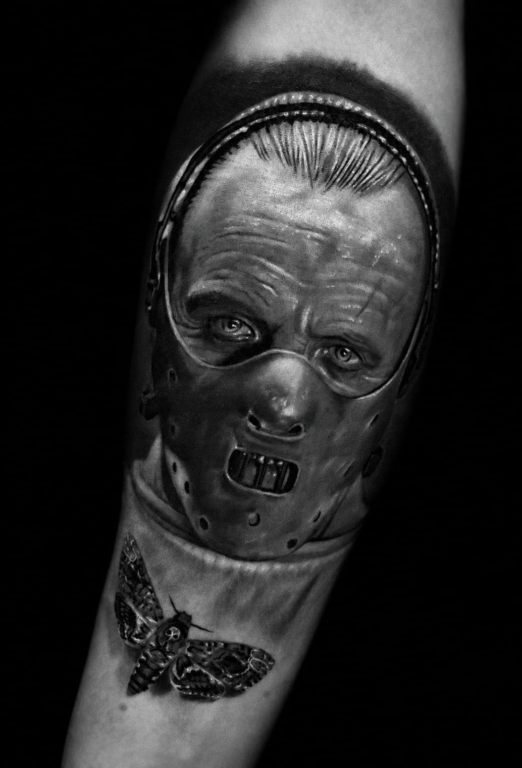 Hannibal Lecter w masce, pod nim ćma trupia główka — realizm black&grey