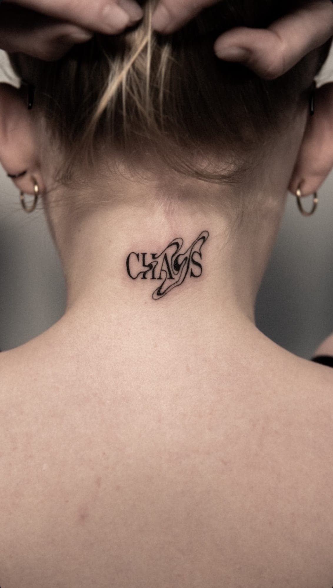 Napis „Chaos” na karku — ozdobne liternictwo