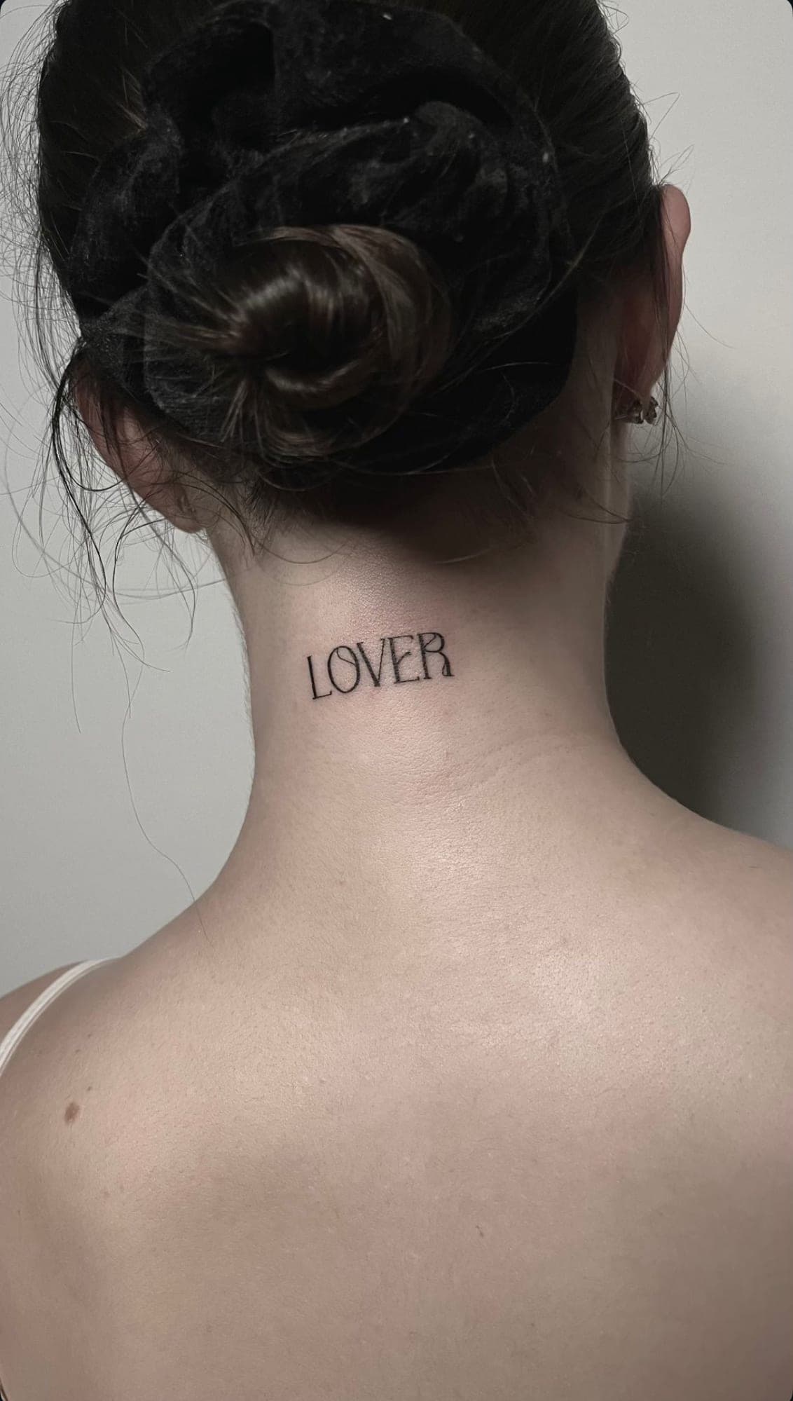 Napis „LOVER” na karku — delikatne liternictwo